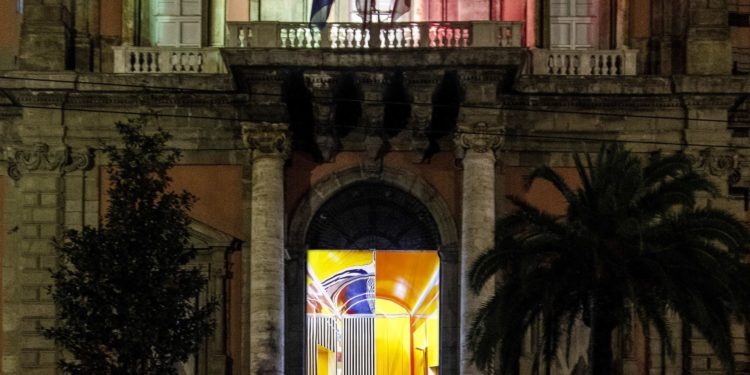 Il portone del Mann illuminato con l'opera di Daniel Buren "Axer désaxer"