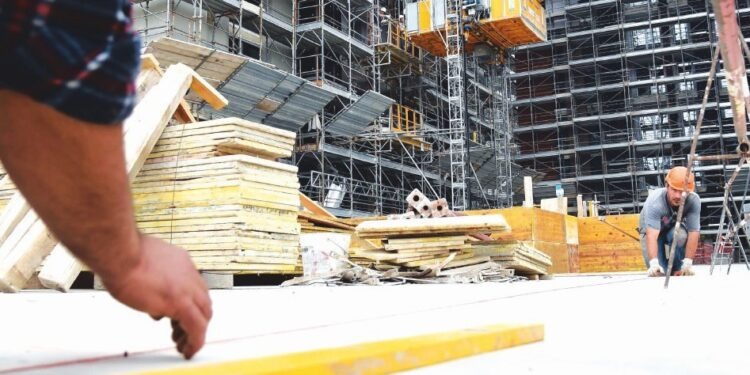 Operai al lavoro nell'area del Village Expo nell'area di Cascina Merlata, composta da 7 torri residenziali, dove dal prossimo maggio saranno ospitati oltre 1330 delegati provenienti dai paesi che parteciperanno all'Expo, 30 settembre 2014. ANSA/DANIEL DAL ZENNARO