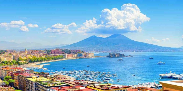 Naples, Italy. View of the Gulf of Naples from the Posillipo hill with Mount Vesuvius far in the background and some pine trees in foreground. Banner header horizontal image. 2021-08-31.